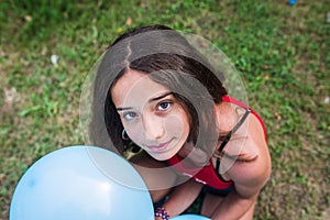 Teenager with balloons and a red beast on the grass