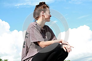 Teenager on a blue sky background enjoying free time