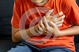 Teenager boy Caucasian holding his chest suffering from pain, heart skip beat.