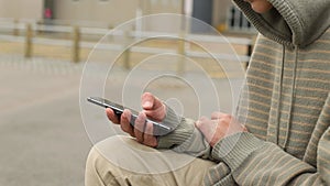 Teenager boy with cell phone on natural background, mobile communication, digital technology