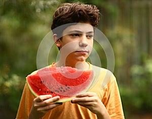 Teenager boy with cut water melon close up photo