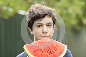 Teenager boy with cut water melon close up photo