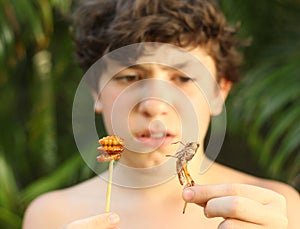 Teenager boy with disgust grimace hold unusial strange thai food