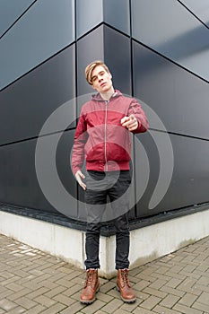 Teenager boy gesticulating and pointing at you ove urban background