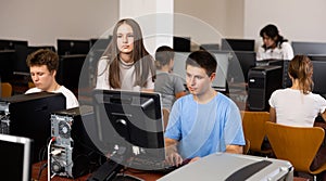 Teenager boy and girl studying in computer class