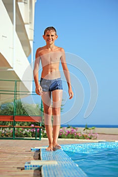 Teenager boy going near pool pool against sea