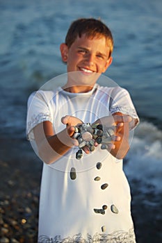 Teenager boy with handful of stones in hands