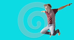 Teenager boy jumping dance movement on a colored blue background