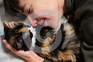 Teenager boy with kitty lying on the sofa. Children`s love for pets