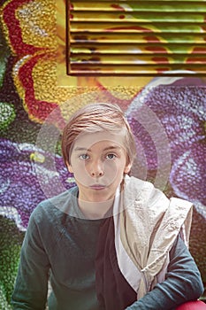 Teenager boy kneeing in front of a flower graffiti photo
