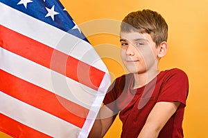 A teenager boy knelt in front of the American flag, young scouts patriots