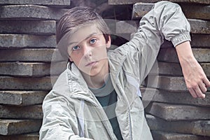 Teenager boy leaning on a stack of flagstones photo