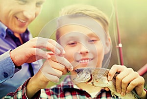 Teenager boy looking at fish on hook