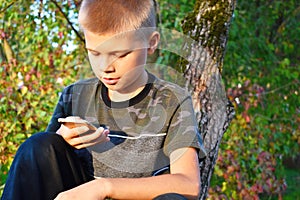 A teenager boy looks at an outdoor phone