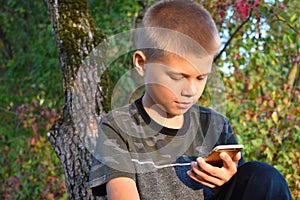 A teenager boy looks at an outdoor phone