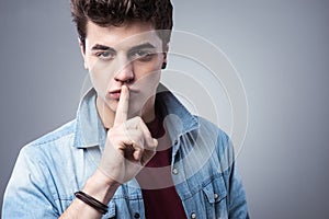 Teenager boy making silence gesture