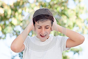 Teenager boy outdoor covering his ears