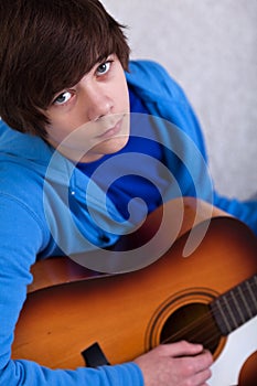 Teenager boy playing the guitar