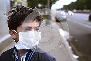 Teenager boy in protection mask on the highway city