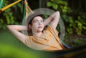 Teenager boy reading in hammock