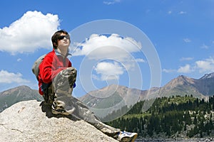 Teenager boy in red sport pullover in mountain