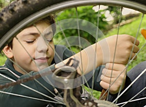 Teenager boy repair bicycle tire close up summer photo