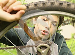 Teenager boy repair bicycle tire close up summer photo