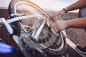 Teenager boy repair tire on bicycle