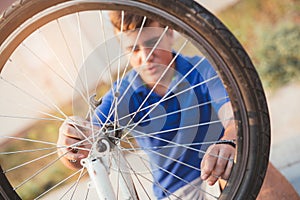 Teenager boy repair tire on bicycle