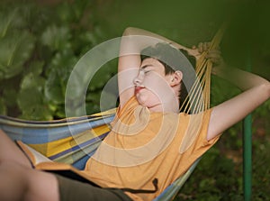 Teenager boy reading in hammock