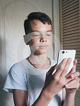 teenager boy with a smartphone in his hand, online social networking and online games