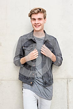 Teenager boy smiling portrait standing over concrete background
