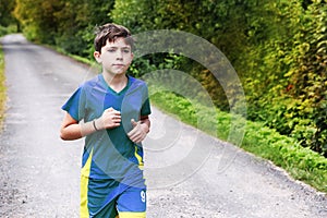 Teenager boy in sportswear run on the country road