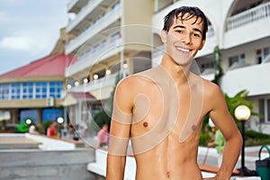 Teenager boy standing near hotel on resort photo
