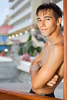 Teenager boy standing near hotel on resort