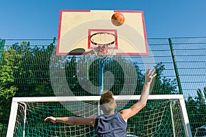 Teenager boy street basketball player on the city basketball court.
