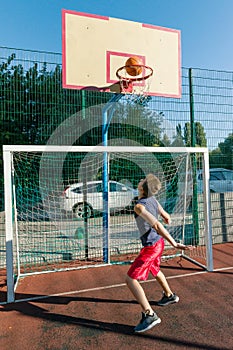 Teenager boy street basketball player on the city basketball court
