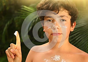 Teenager boy with sun screen protection cream close up smiling photo