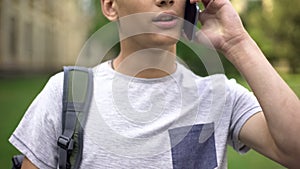 Teenager boy talking on smartphone, good mobile coverage in city, communication