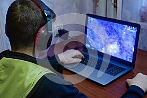 Teen plays computer games, The boy sits at home computer. Reading, boys