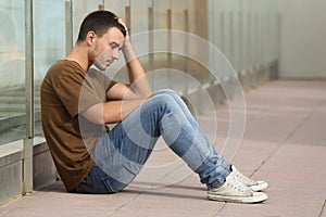 Teenager boy worried sitting on the floor photo