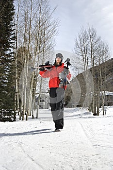 Teenager carrying ski gear.