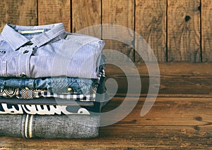 Teenager casual outfit. Boys shoes, clothing and accessories on wooden background - sweater, shirt. Top view. Flat lay.