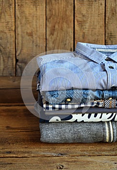 Teenager casual outfit. Boys shoes, clothing and accessories on wooden background - sweater, shirt. Top view. Flat lay.