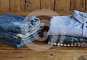 Teenager casual outfit. Boys shoes, clothing and accessories on wooden background - sweater, shirt, trousers, jeans. Top view.