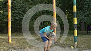 Teenager catching ball standing stadium gate playing football outdoors, hobby