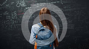Teenager in class on background of blackboard