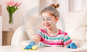 Teenager cleaning table in living room