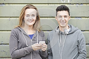 Teenager Couple Sharing Text Message On Mobile Phone