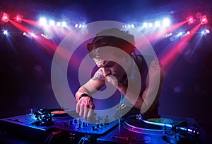 Teenager dj mixing records in front of a crowd on stage